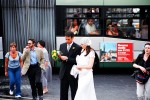 Passengers on a bus catch a glimpse of a groom with his bride moments after their marriage vows.