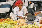 A vendor sells fruit and vegetables near the facade of Hawa Mahal.