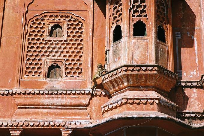 The Hawa Mahal, made of red and pink sandstone, was originally constructed to offer women of the court a vantage point, behind stone-carved screens, to watch the street activities below. 