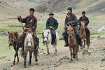 A group of young horse riders suprised by the presence of foreign tourists. Many Mongolians learn to ride horses and camels at an early age.