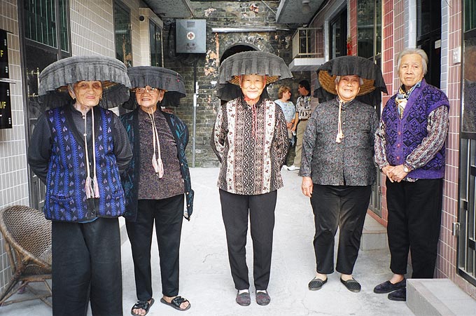 The Hakka women of Kat Hing Wai, a walled village in the New Territories, continue to wear their traditional broad brimmed hats, especially for snap-happy tourists.