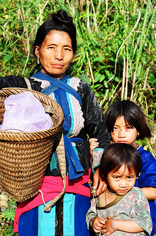A hill tribeswoman and her children return home after a day's work in the field in northern Thailand.