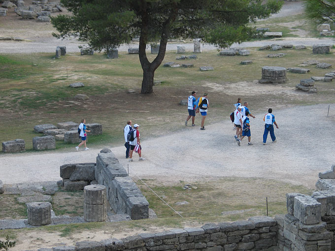 Shot putters and volunteers walk amid the ruins at ancient Olympia, the birthplace of the Olympics.