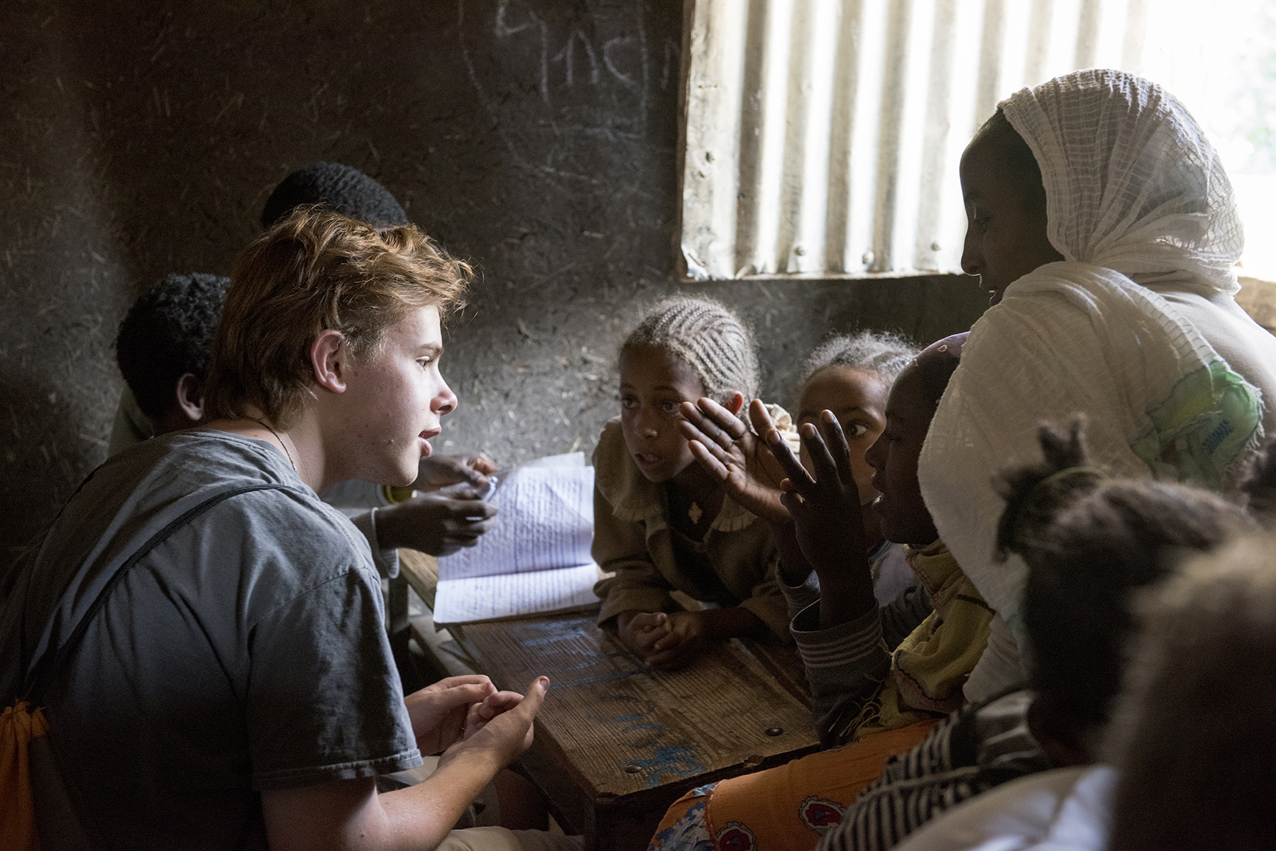 Young members of a rural community in Lalibela, Ethiopia, gather around Elon students to share stories and practice their English.