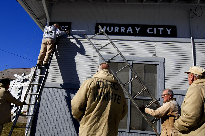 Inmates from Ohio's Hocking Correctional Facility hang newly painted signs on the historic train depot in Murray City, Ohio, a former coal  mining town. The depot was built around the turn of the century and is one of only three original historic train depots left in Ohio.