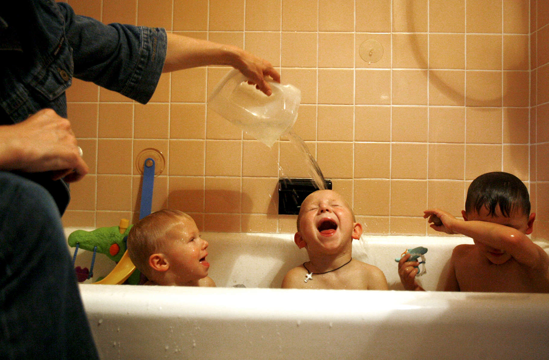 Stefanie Senkiw Krebs pours water over the head of her new son Patrick, 4, while he bathes with his biological brother Joseph, 2, (left) and adoptive brother Peter, 4. Senkiw Krebs and her husband had just returned to their N.Y. home after adopting three brothers from the Ukraine, bringing their family to a total of four adopted children.