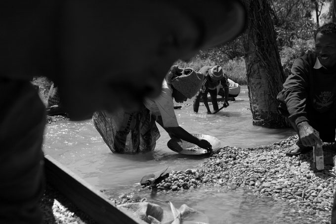 Men, women and children sift for poorer quality stones in a muddy river. Stones are rarely found in the mine itself but are sifted out in several series of washings. The more abundant mines sift very privately with trusted, guarded employees for fear of theft or even the spread of word that a good gem has been found.