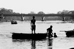A Honduran man crosses the river between Tecun Uman, Guatemala and Ciudad Hidalgo, Mexico on his way to the U.S.  For 5 pesos per person -- approximately 60 cents --hundreds cross the river illegally. The bridge in the background is a heavily guarded, legal entry point..