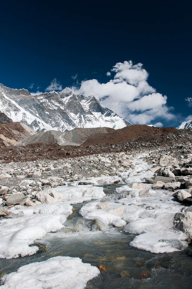 As winter approaches, the upper reaches of this river begin to freeze over. The terminal moraine of the Lhotse Nup glacier is beyond, with the south face of Lhotse towering above.Nikon D300, 17-35mm. November 2008