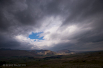 A view to Mungrisedale and Mosedale, with Blencathra on the left, Bowscale Fell and Carrock Fell catching the sun under a stormy sky.