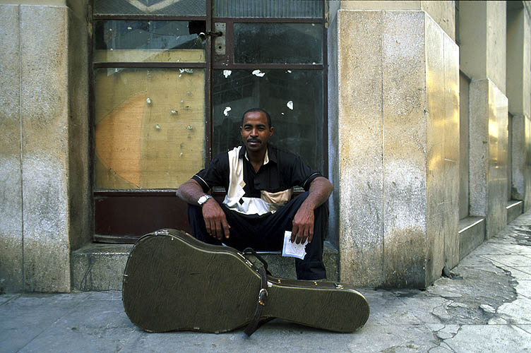 A guitarist pauses on his way to work in one of the bars in the old city.Nikon FM2, 24mm, Fuji Velvia