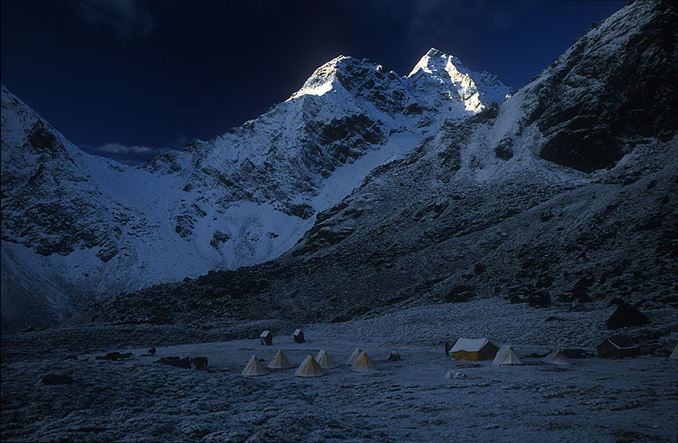 While the scintillating first rays of sun catch the peaks above, this camp lies in the grip of the night's heavy frostNikon F5, 17-35mm, Fuji Velvia 100