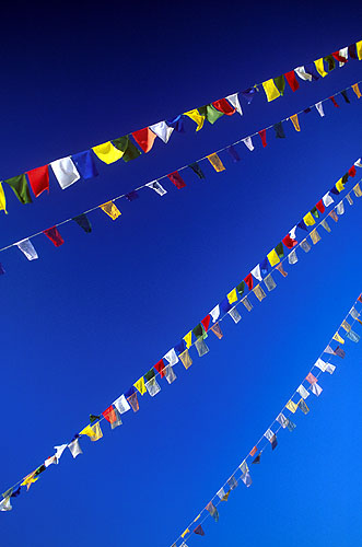 Against an azure sky, prayer flags flutter in the breeze at BodnathNikon FM2, 50mm, Fuji Velvia