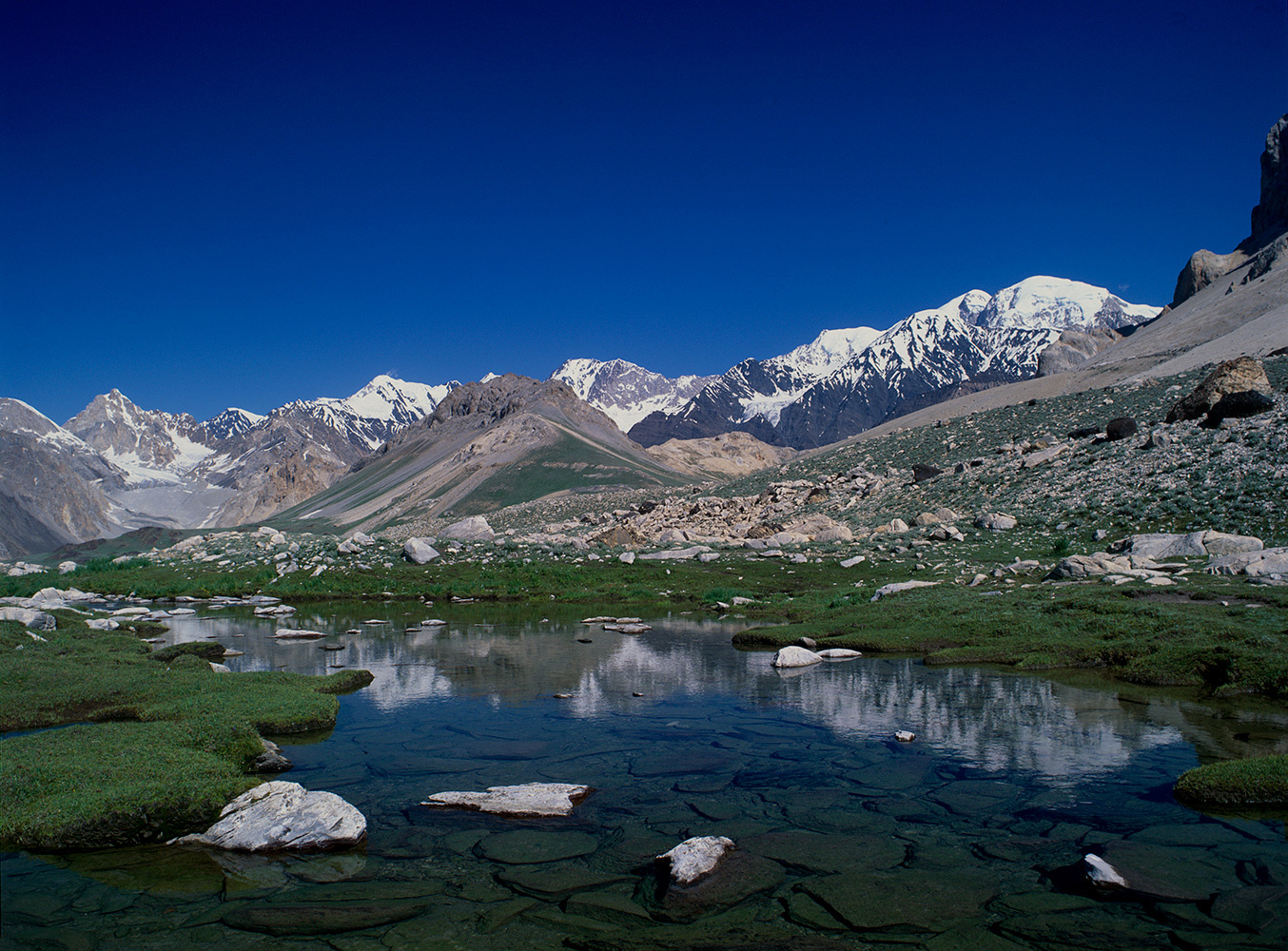 The Shah Jinali pass links the upper Turikho valley with the village of Lasht in the Yasrkhun. This picture was taken looking south into the upper Shah Jinali Gol from the meadows immediately below the col. The name Sha Jinali means {quote}King's Polo Ground{quote}.Bronica ETRSi, Fuji Velvia