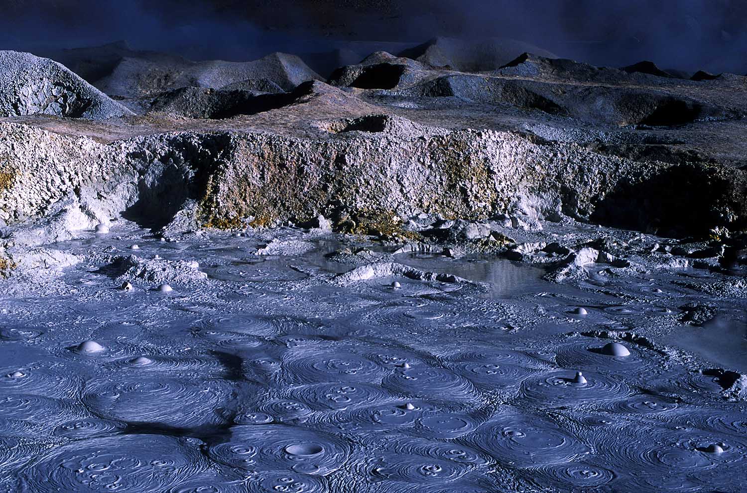 Volcanic site - pools of boiling mud in an array of colors.Sitio volcánico - piscinas multicolores de fango hirviendo.
