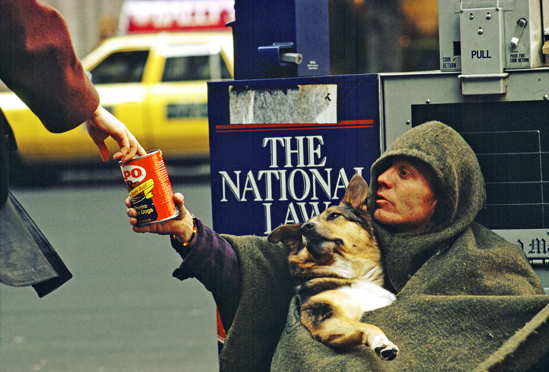 Homeless man with his dog begging on 5th Avenue in New York City.