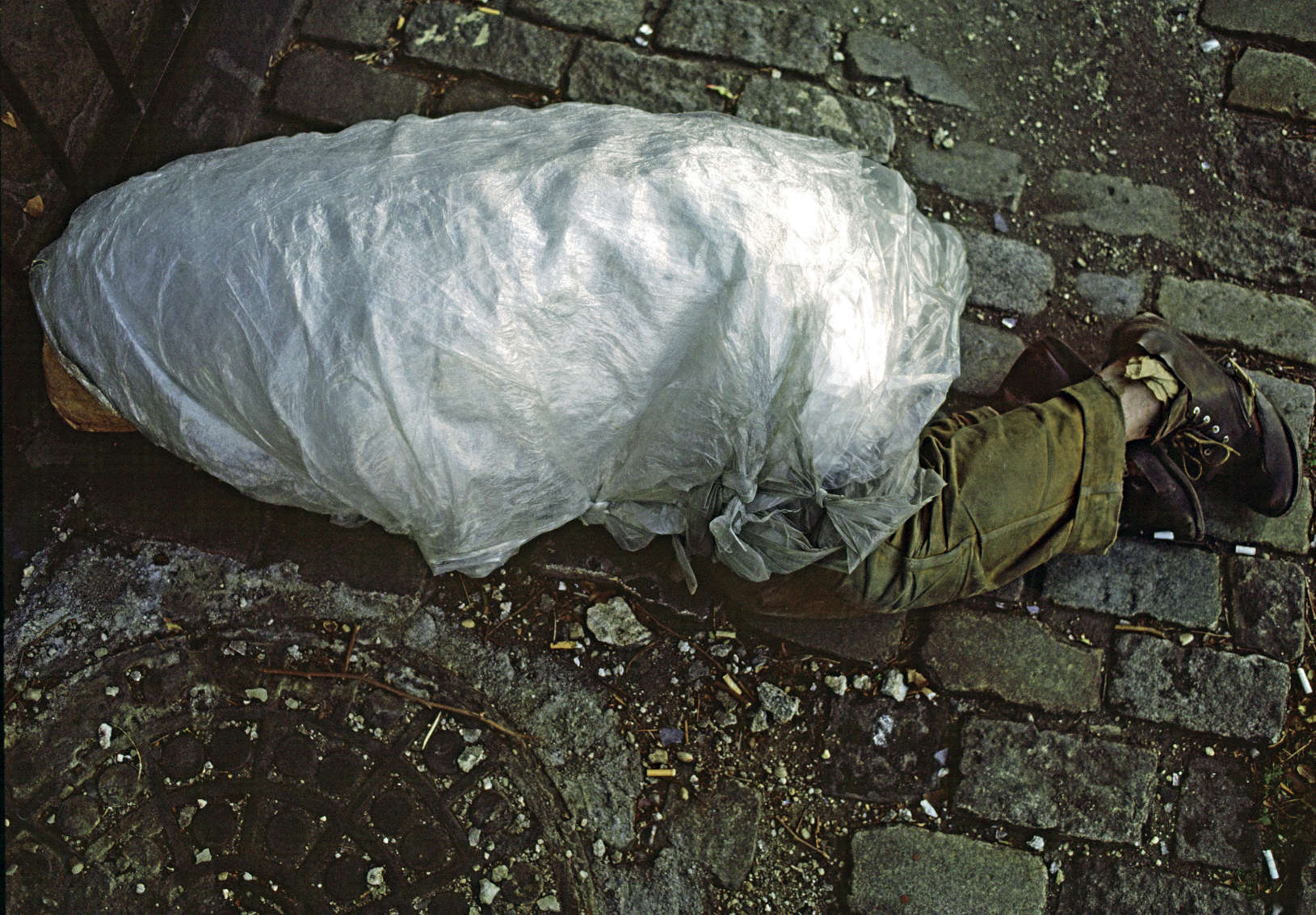 Homeless man wrapped in plastic to keep warm on a minus zero degree temperature day in the winter in New York City.