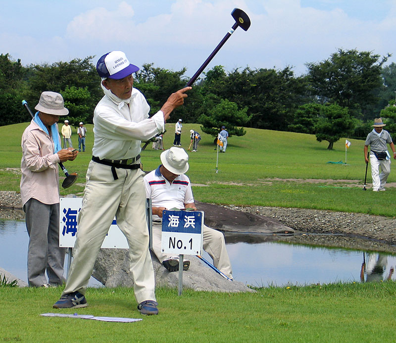 A man tees off on hole one of a park golf course in Honshu. Park golf is a sport very popular all over Japan, especially with the elderly. It is a combination of regular golf and mini golf, with a croquet flavour.