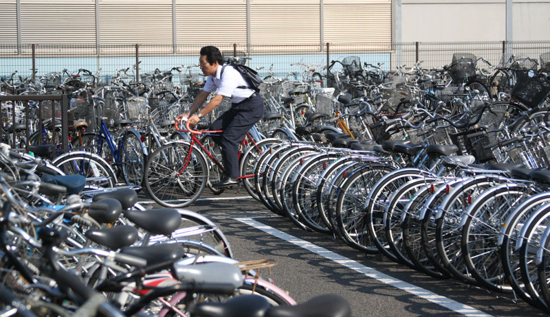 A man rides his bike through the Nagano Station bike parking during rush hour in Nagano, Honshu.