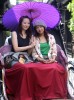 Two girls take some shade and pose for a photograph while on a rickshaw tour in Takayama, Honshu, Japan.