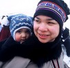 An Inuk woman keeps her baby warm in a traditional kamik while enjoying the sights and sounds of Caribou Carnival in Yellowknife, NWT.  