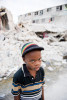 PORT-AU-PRINCE, HAITI (2/6/10)-Seven year-old Wesley Paul stands in front of a collapsed building in Port-au-Prince.   © Habitat for Humanity International/Ezra Millstein