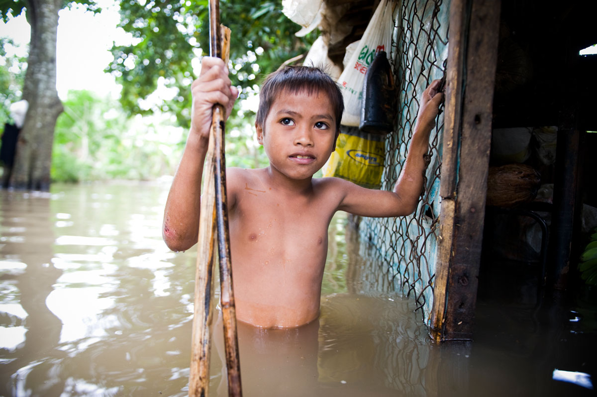 A boy wades through floodwater next to his house, as Typhoon Mirinae batters the Philippines.  Mirinae was the fourth storm to strike the country in a month.© Habitat for Humanity International/Ezra Millstein