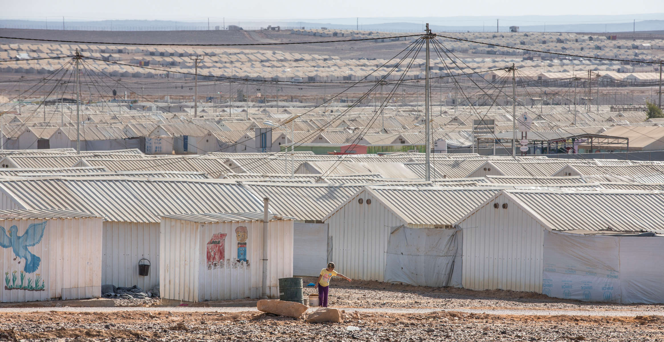 A boy draws water from a well at Azraq refugee camp. The camp first opened in April 2014. It houses over 20,000 refugees from the conflict in Syria.