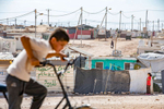 Children play on the outskirts of Zaatari refugee camp. Mercy Corps operates a safe space inside Zaatari, where Syrian refugees learn about healthy parenting strategies and make traditional Syrian crafts that help them stay connected to their home. The space, which features a playground, garden, soccer field, and classrooms, gives adults and children a safe place to stay in the middle of the dusty camp.