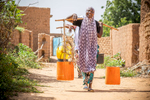Halima Issoufou, 26, collects water for her family. Halima lives with her husband and three children in a rudimentary mud hut in a rural village outside Niger’s capital city, Niamey. Families here rely heavily on agriculture and nearly everyone lives hand-to-mouth. Halima’s family is no exception, and her daily life is not unlike every other woman’s in her village: from sunrise to sunset she works to care for the household, spending most of her time laboring over the day’s next meal. Every day she cleans the home and dishes, collects water and firewood, and pounds millet to make the family’s porridge, an arduous, lengthy process which she finishes just in time to start again. But all this work isn’t enough, and the family often goes without eating — poverty is rife and they are not able to grow enough food to last them the year. “In this area, people’s lives are based on agriculture, which does not answer their needs because of the rain,” Halima explains. “People constantly face drought, and that makes people suffer a lot.”Between 2014 and 2016, Mercy Corps’ ECOUT program responded, providing them with millet seeds; cash-for-work to restore farmland; goats; and training on agriculture, nutrition and hygiene. While conditions remain harsh and finding enough food is still a daily struggle, the family is still feeling some of the benefits from that program, particularly the hygiene and sanitation training, through which Halima learned to wash her dishes before cooking, and exclusively breastfeed her children for the first six months of life.