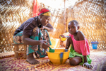 Halima Issoufou, 26, shares a meal of millet porridge with her daughgter. Halima lives with her husband and three children in a rudimentary mud hut in a rural village outside Niger’s capital city, Niamey. Families here rely heavily on agriculture and nearly everyone lives hand-to-mouth. Halima’s family is no exception, and her daily life is not unlike every other woman’s in her village: from sunrise to sunset she works to care for the household, spending most of her time laboring over the day’s next meal. Every day she cleans the home and dishes, collects water and firewood, and pounds millet to make the family’s porridge, an arduous, lengthy process which she finishes just in time to start again. But all this work isn’t enough, and the family often goes without eating — poverty is rife and they are not able to grow enough food to last them the year. “In this area, people’s lives are based on agriculture, which does not answer their needs because of the rain,” Halima explains. “People constantly face drought, and that makes people suffer a lot.”Between 2014 and 2016, Mercy Corps’ ECOUT program responded, providing them with millet seeds; cash-for-work to restore farmland; goats; and training on agriculture, nutrition and hygiene. While conditions remain harsh and finding enough food is still a daily struggle, the family is still feeling some of the benefits from that program, particularly the hygiene and sanitation training, through which Halima learned to wash her dishes before cooking, and exclusively breastfeed her children for the first six months of life.