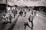 Residents of Goma cut off from outside and without food, desperately chase after a World Food Program truck distributing the last of its supplies.