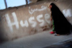 Women walk past the name of Imam Hussein, the son of Imam Ali, founderof Shia Islam, scrawled on a wall. Under Saddam Hussein, such a statement of Shiite faith and solidarity would have been viewed as a threat to the unity of the state. Since the U.S. invasion, Sadr City has become an open book of religious and political graffiti. 