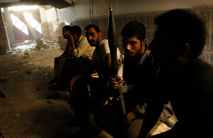 Soldiers of the Mahdi Army wait in the basement for their rotation in frontline fighting as the building is pummeled by U.S. tank shells. 