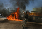 An Iraqi boy celebrates after setting fire to a damaged U.S. vehicle that was attacked earlier by insurgents.