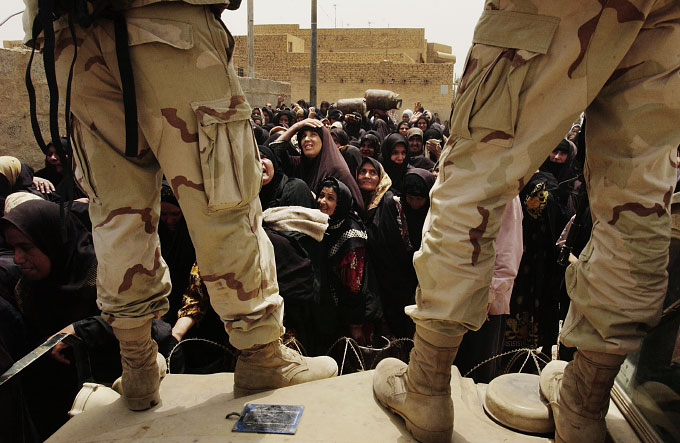 Women struggle to form a line at a gas distribution center. The U.S. army, in cooperation with the former Iraqi government's distribution ministry, set up the center to provide essential fuel for cooking and water purification.