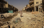 A lone man walks through a thoroughly destroyed business and residential street west of the Imam Ali shrine in Najaf. The street was a front line fighting position for American army and Mehdi Militia fighters during a nearly three-week battle that left much of the old cit of Najaf and surrounding neighborhoods in ruins.