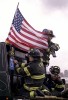 Firefighters ride on the back of a flatbed truck towards Ground Zero.