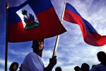 Residents of Gonaives hold their national flag during a patriotic street rally. 