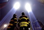 Firefighters John Leimeister, left, and Sean MacPherson of Engine 292 pause to look up at the Towers of Light Tribute before continuing their search for human remains at Ground Zero.