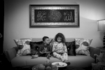Souad and two-year-old Hassan play on mobile devices as they sit together on the living room sofa. Michael Appleton/Mayoral Photography Office
