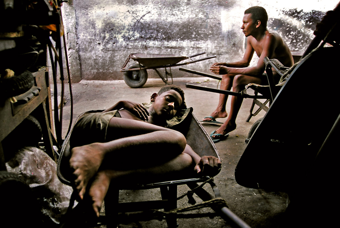 Two boys resting in an open market in Salvador. 