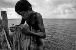 A boy climbing out of the Tapajos River after diving.Amazon, Brazil