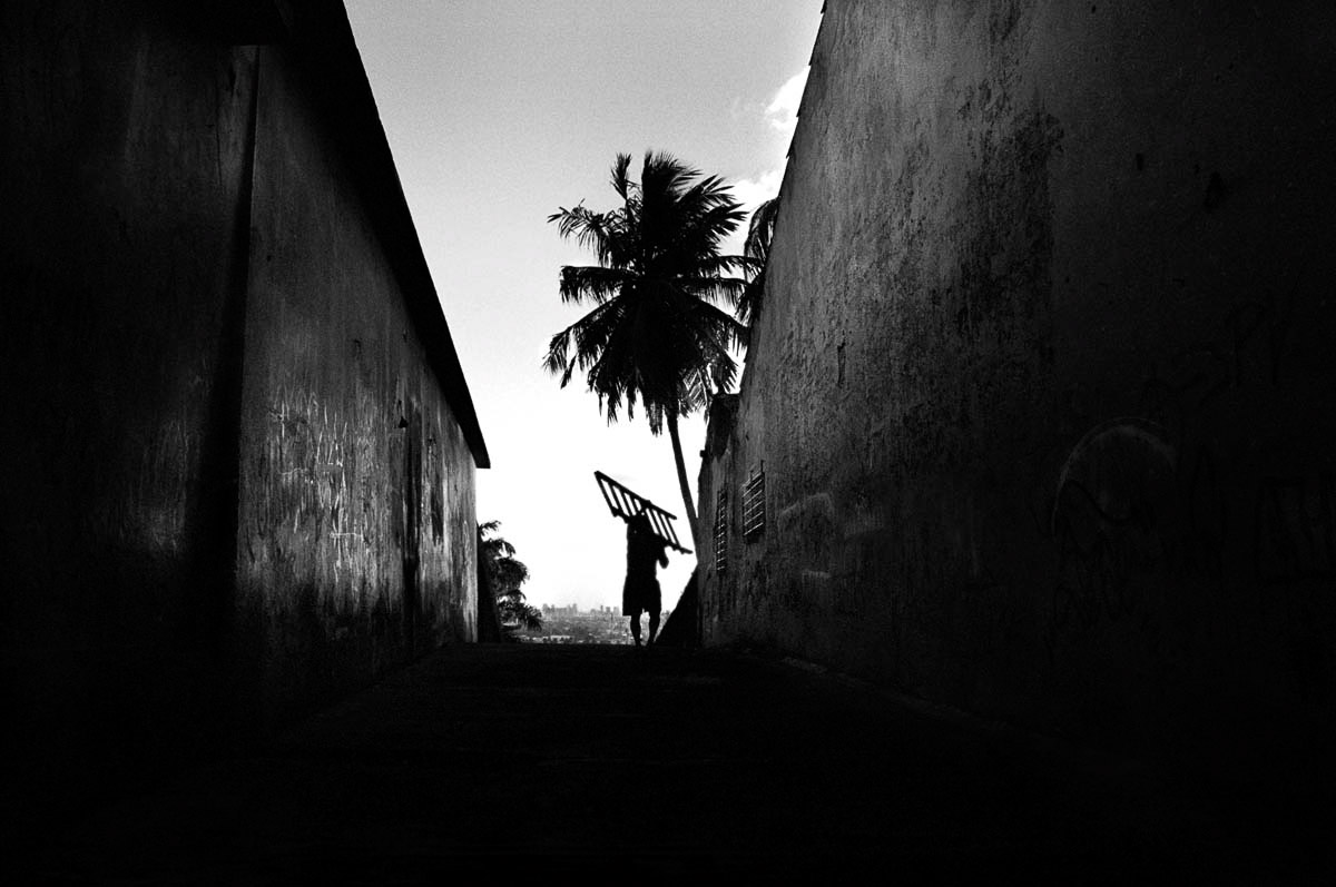 A man carrying a ladder in Olinda, Brazil.