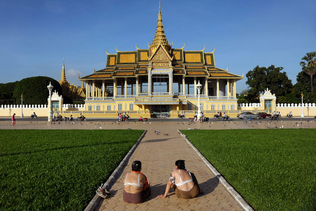 Two elder women sunbathing in front of the Royal Palace.