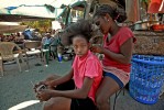 A girl having her hair combed and braided.