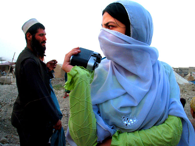 Farshta Kohistani, 19 years old photographer for UNAMA, photographing in a Kuchi camp outside of Kabul Afghanistan.