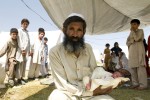 Said Wahid holding his newborn grandson, Sahil under his tent at the Swabi IDP camp in Swabi, Pakistan.  Sahil was born 3 days ago, just a few days after this refugee family had fled Swat and moved to the IDP camp for safety.  Photographed in Swabi, Pakistan on May 20, 2009.  There are now 1.5 million displaced people in Pakistan's North West.  
