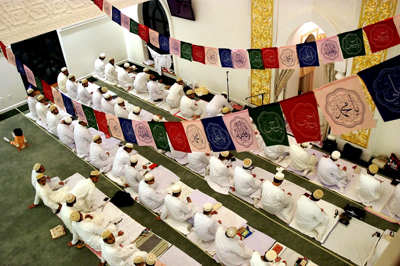 Muslim men pray in the central quarters of the mosque while women pray on the balcony above.