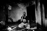 42 year-old  Detroit squatter Kevin Smith smokes in the abandoned house where he live. Many, like Kevin, become squatters as the town face the severe economic downtown.